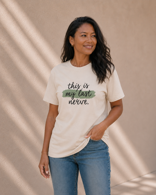 Woman modelling The Bare Minimum Club's vintage white 'This Is My Last Nerve' t-shirt, smiling in natural light