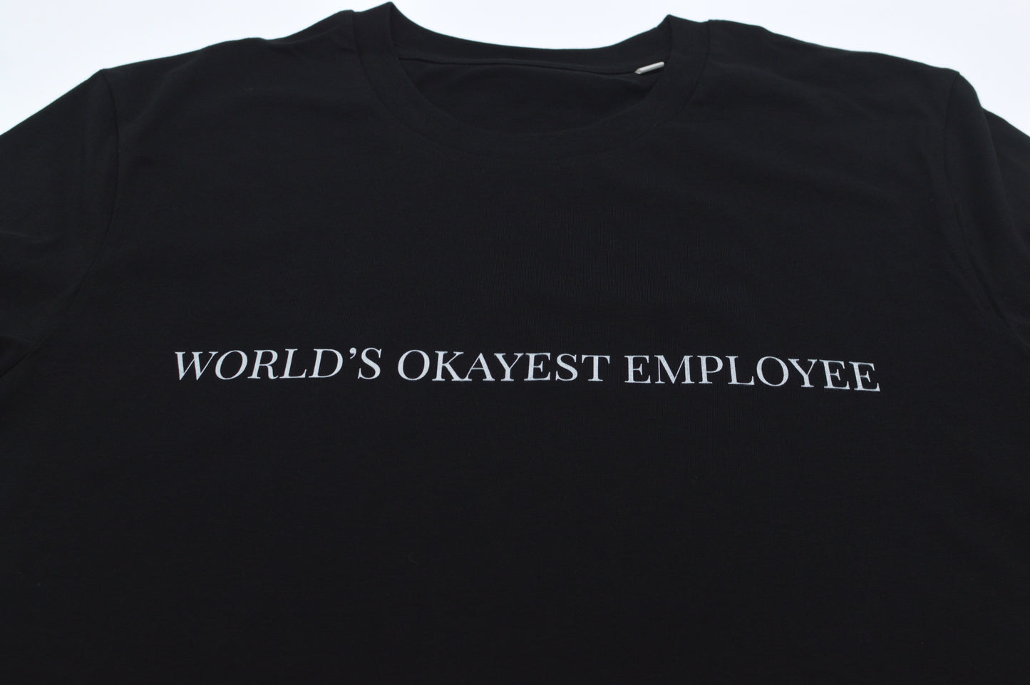 Black t-shirt with 'World's Okayest Employee' text on a white background
