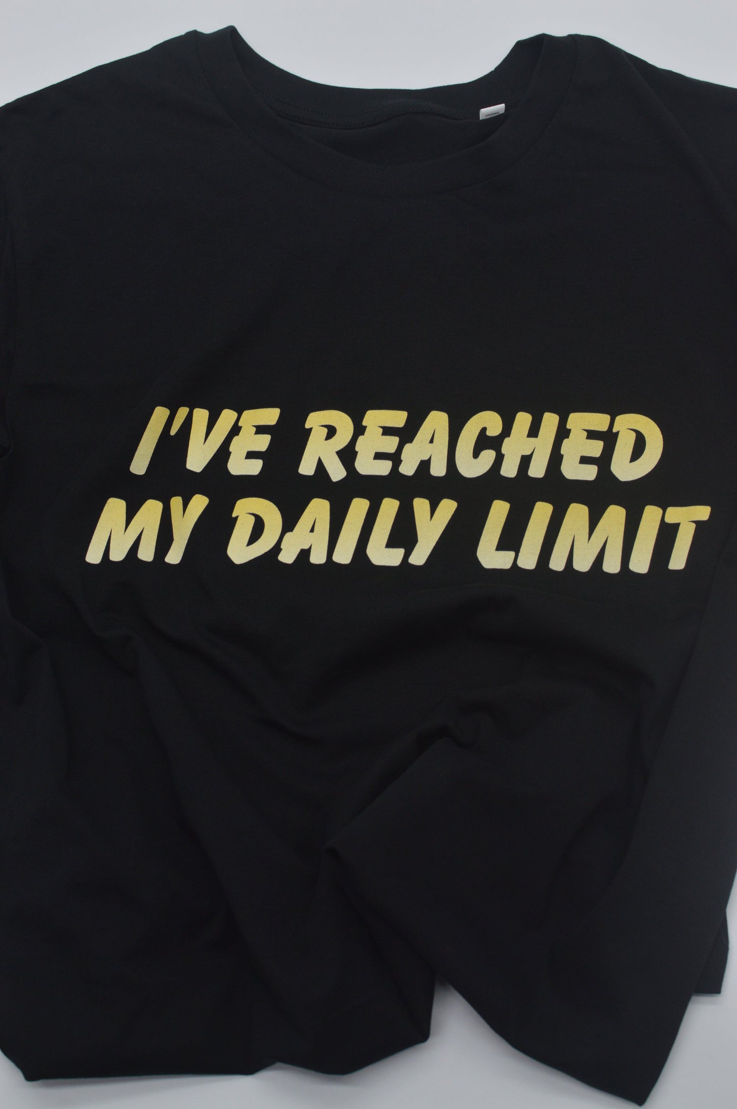 Black t-shirt with yellow text 'I'VE REACHED MY DAILY LIMIT' on a white background