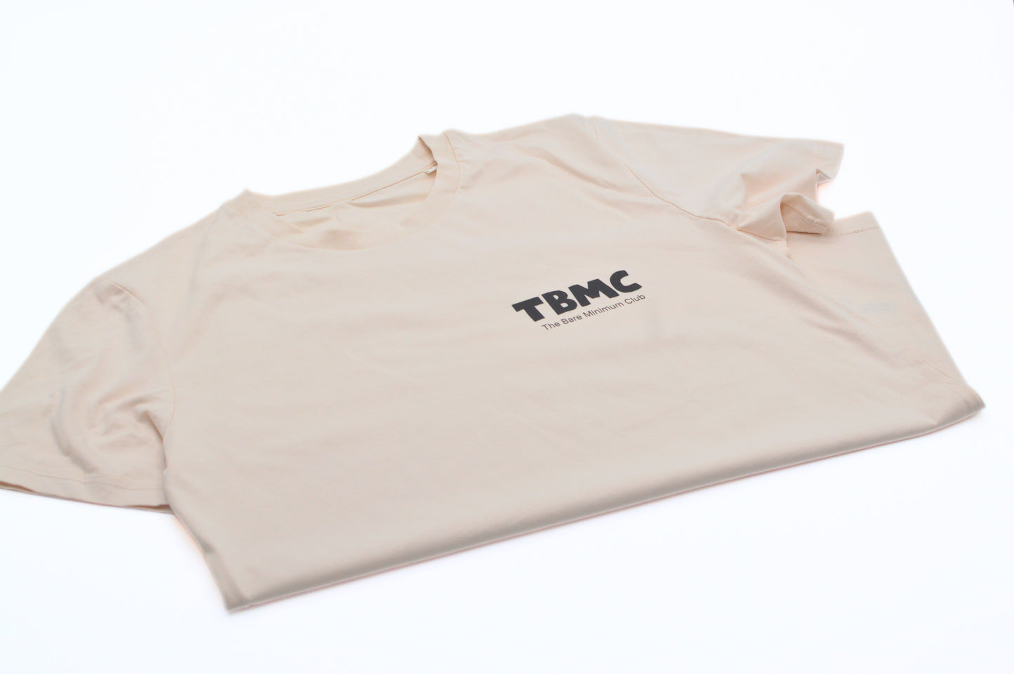 Folded vintage white t-shirt with 'TBMC' logo on a white background