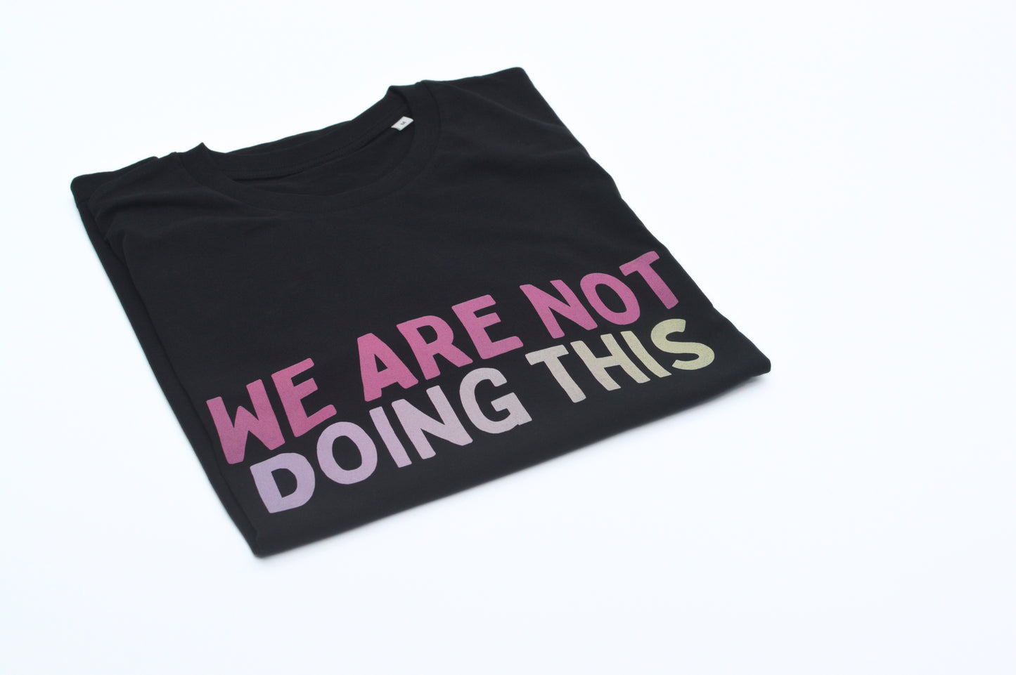 Black t-shirt with colorful text 'WE ARE NOT DOING THIS' on a white background