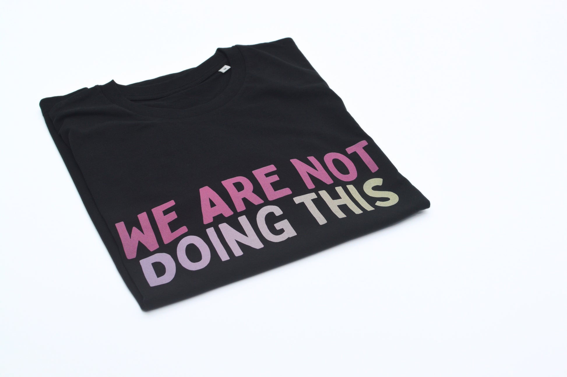 Black t-shirt with colorful text 'WE ARE NOT DOING THIS' on a white background