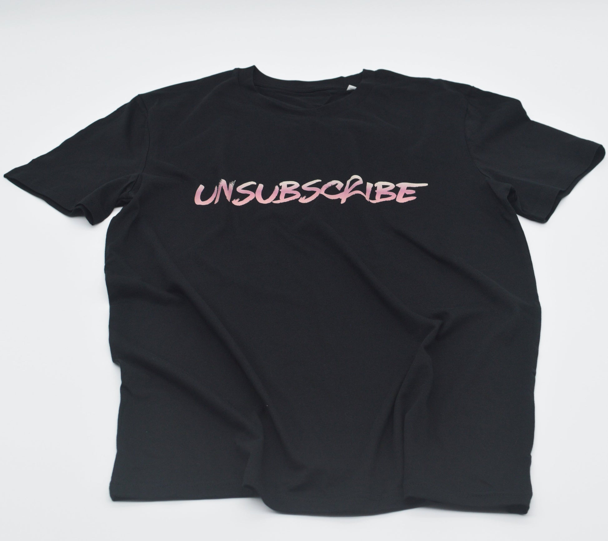 Black t-shirt with 'UNSUBSCRIBE' text in pink on a white background