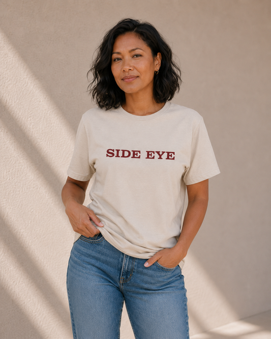 Woman modelling The Bare Minimum Club's vintage white 'Side Eye' t-shirt in natural light
