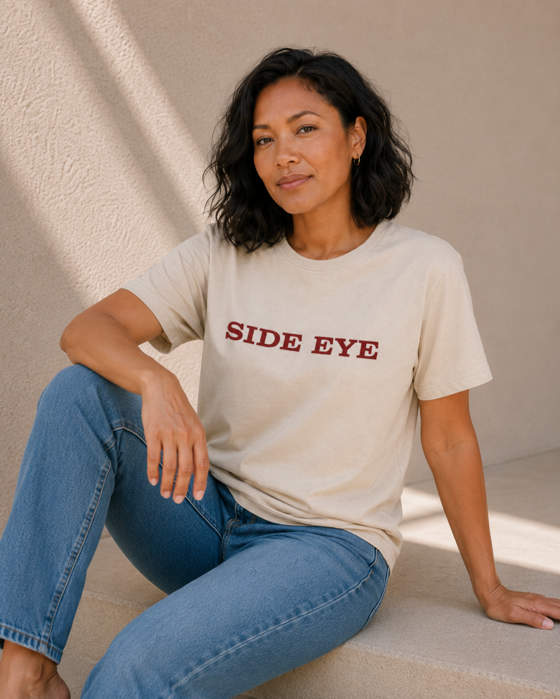 Lifestyle photo of The Bare Minimum Club's vintage white 'Side Eye' graphic t-shirt styled with blue jeans