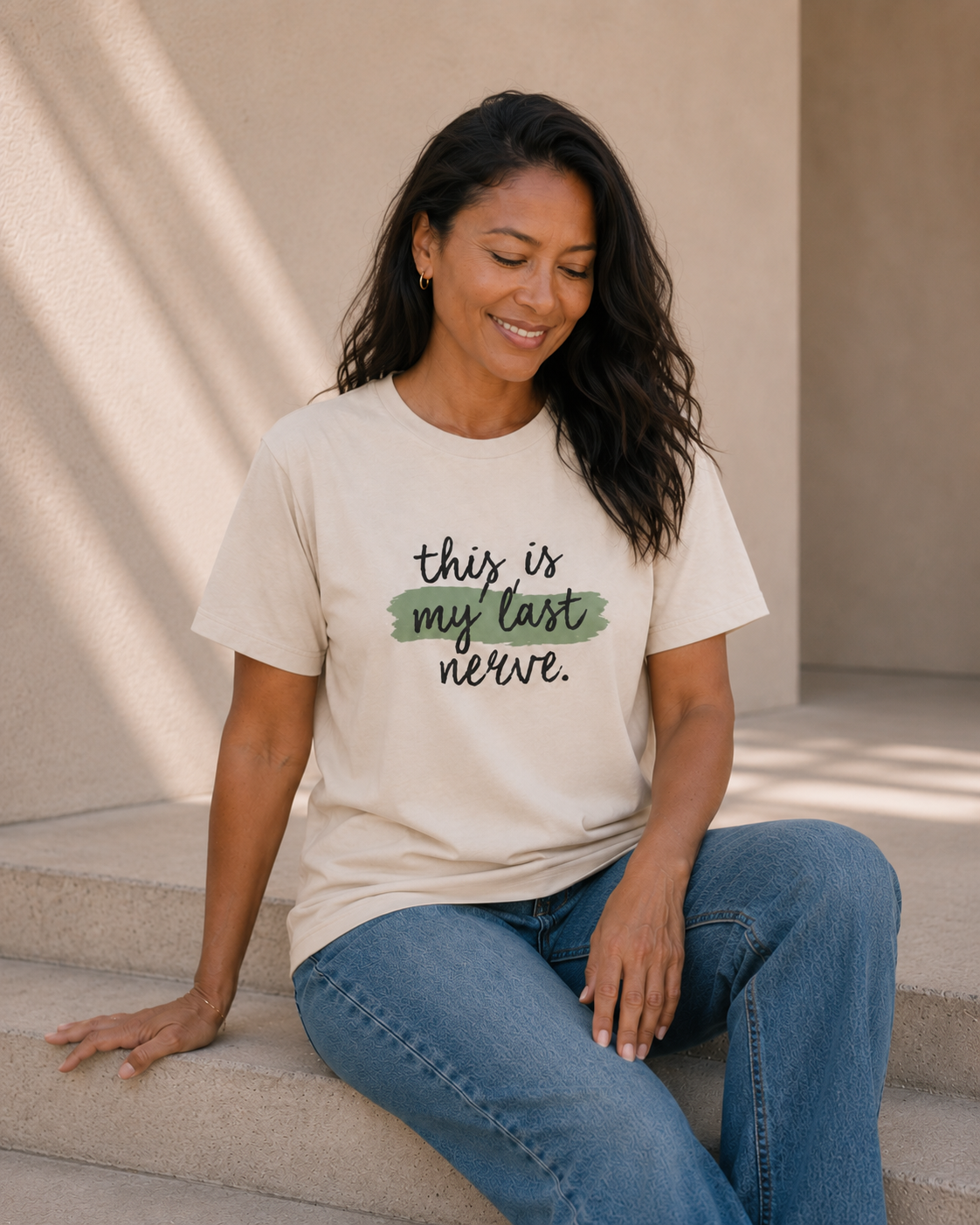 Lifestyle photo of The Bare Minimum Club's vintage white 'This Is My Last Nerve' graphic t-shirt styled with blue jeans